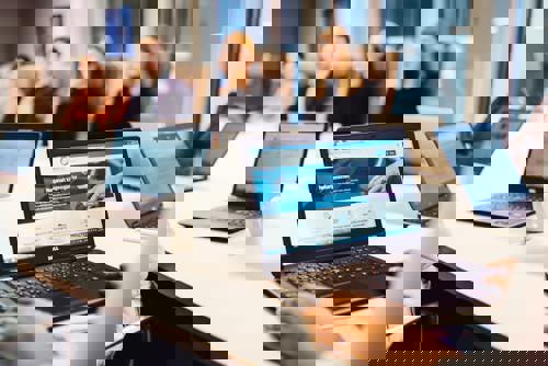 Ansatte som sitter rundt et møtebord. På en PC-skjerm vises lovdata.no. Foto: Cecile Bannow.